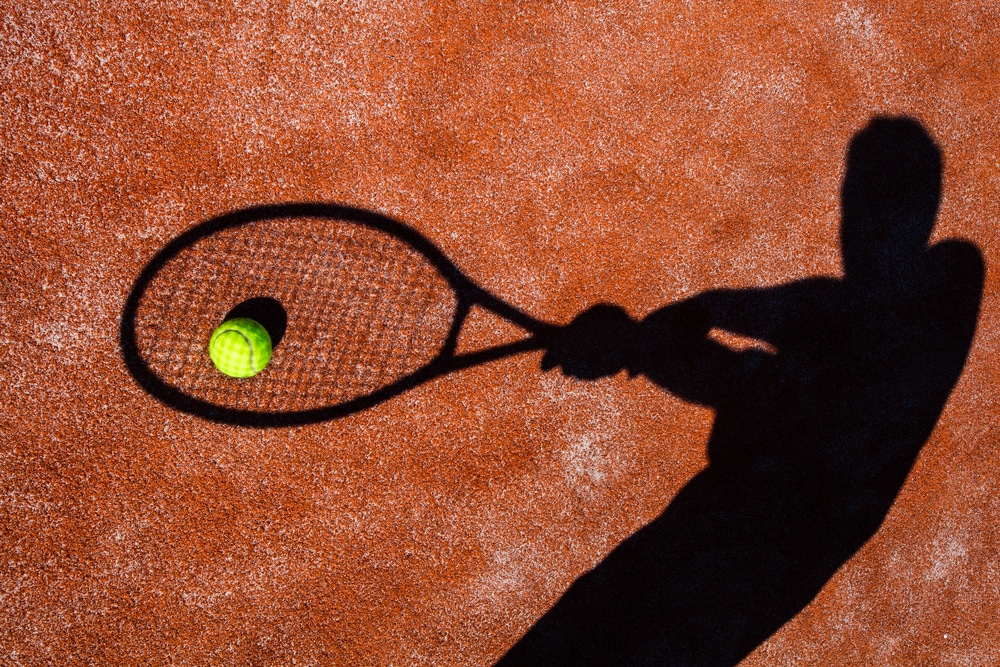 A shadow of a person playing tennis shot