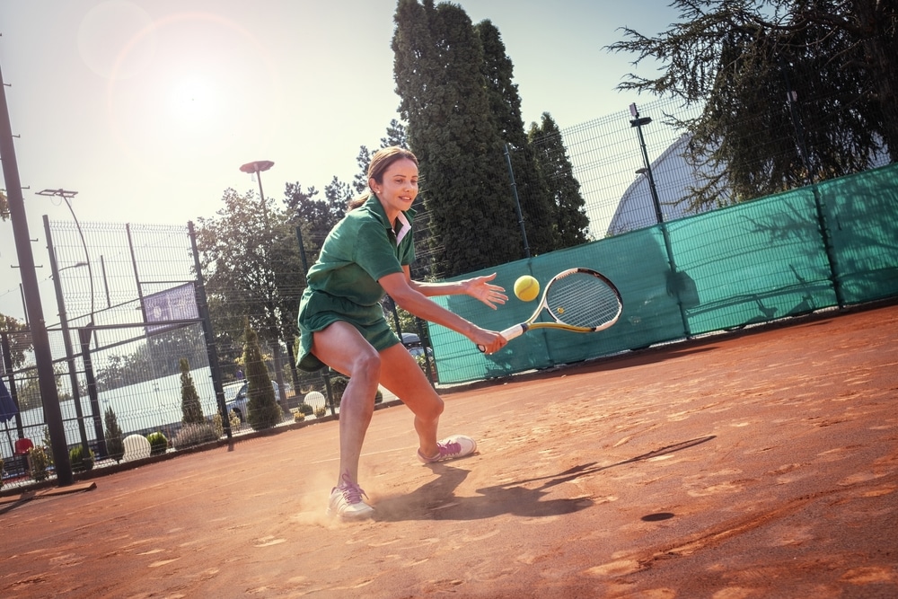 A view of a female girl hitting a tennis shot