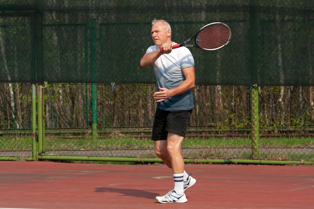 A view of a person holding a tennis racket on court