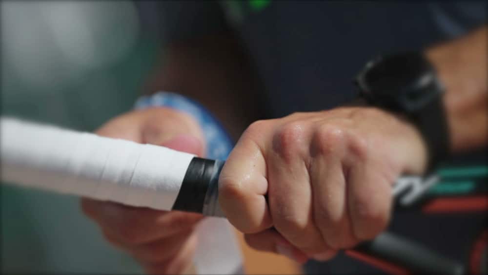 A view of a person holding the tennis racket grip