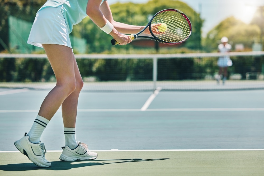 A view of a woman serving in a tennis court