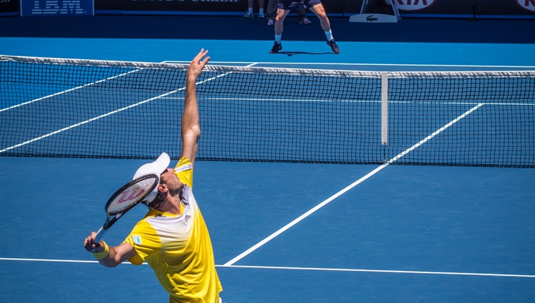 a player setting the position of arm in a tennis court while playing