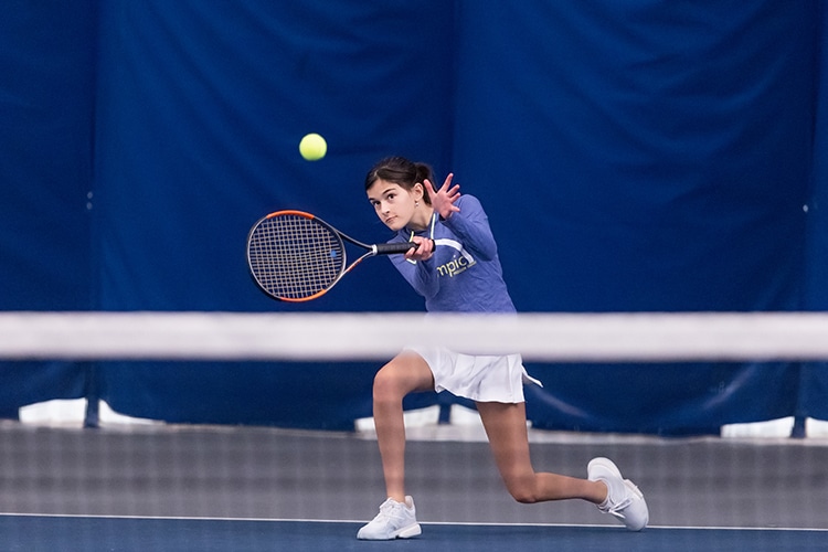 girl playing indoor tennis