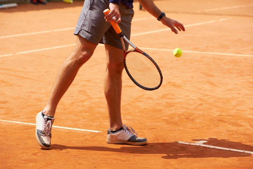 Tennis Court And Legs Of Person Outdoor At Start Of