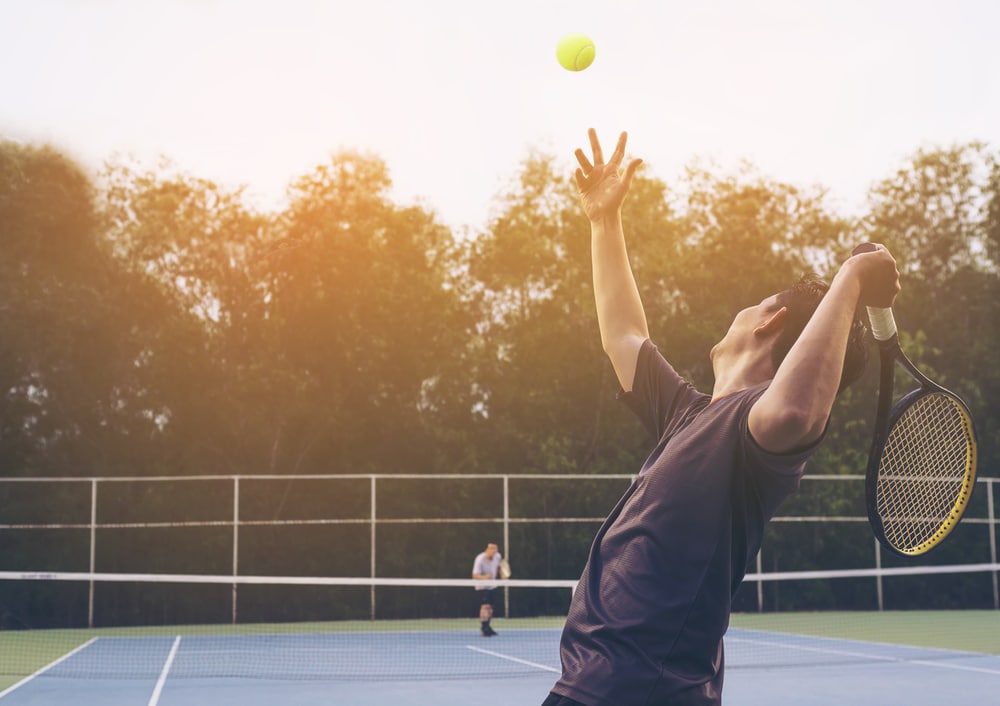 A backview of a person hitting a shot in tennis