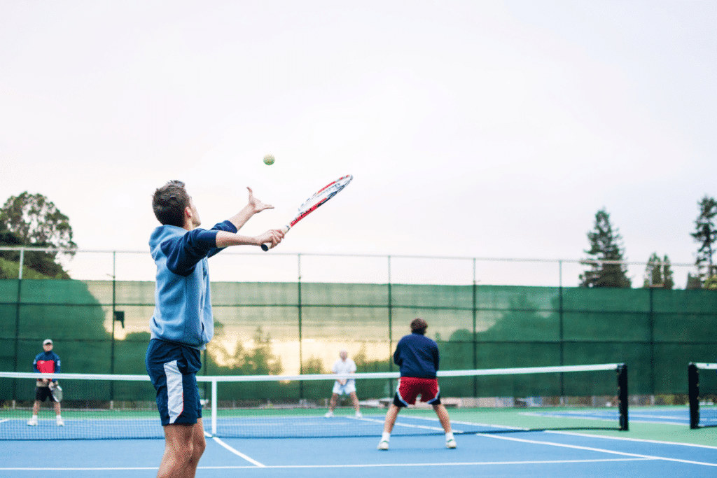 A view of a person serving at a tennis court