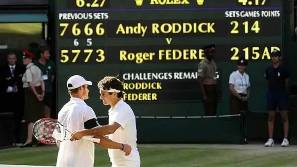 A view of a tow players hugging with a backdrop of tennis scores and thier names showing