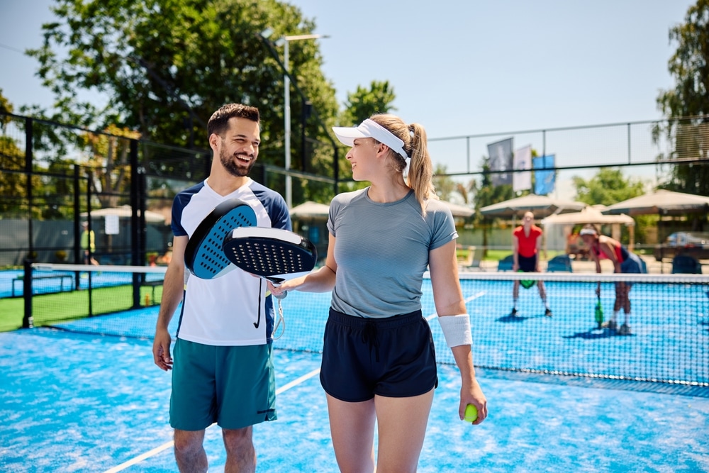 Happy Paddle Tennis Players Communicating During A Match On Outdoor Court