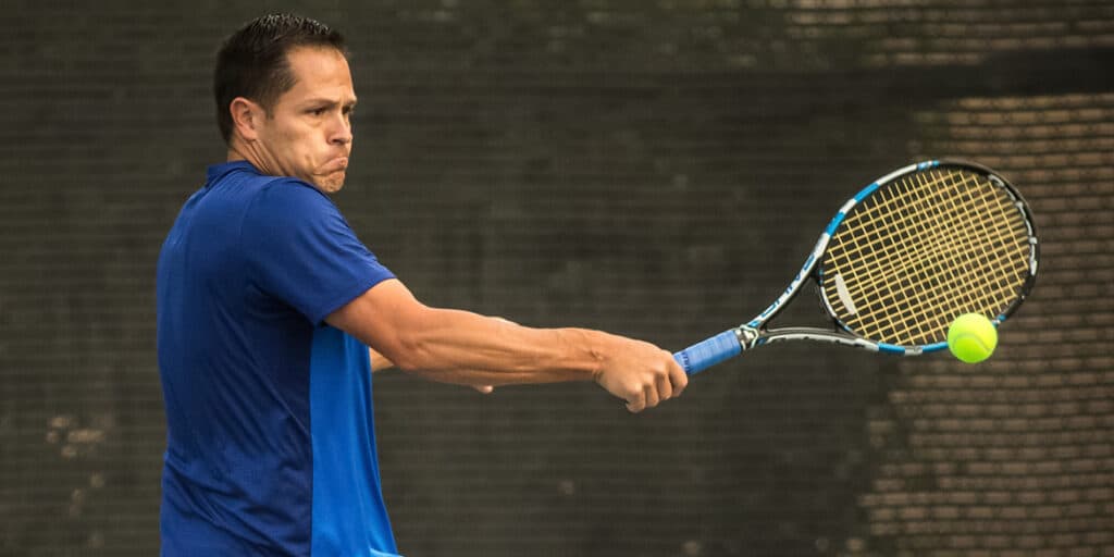 male player hitting backhand tennis shot