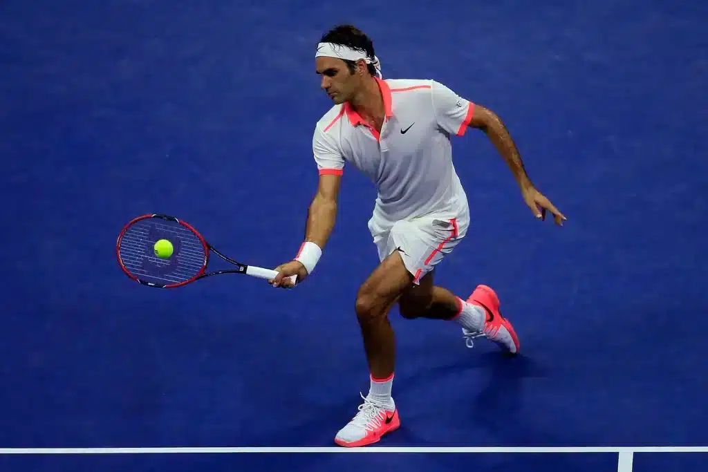 young male player holding a racket hitting dropshot