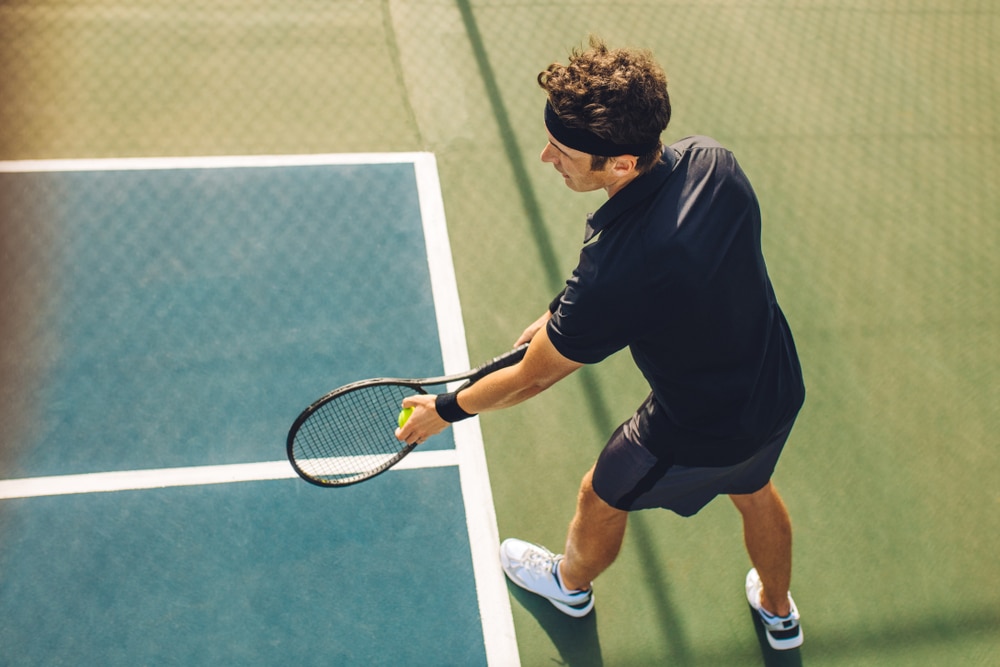 Professional player standing at the baseline holding the tennis racket 